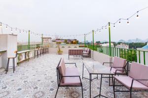 Un patio con sillas y mesas en un balcón. en Blue Eyes Hotel, en Văn Lâm