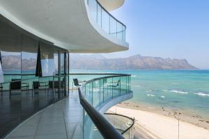 ein Gebäude mit Blick auf den Strand und die Berge in der Unterkunft Ocean View 505 Self Catering Accommodation Strand Western Cape South Africa in Strand