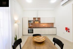 a kitchen with a wooden table and black chairs at LIVE like a Local - 3 Cities Home & 2 KING BED by 360 Estates in Cospicua