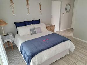 Un dormitorio con una cama grande con una manta azul. en Ocean Breeze, en Mossel Bay