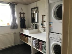 eine Waschküche mit einem Waschbecken und einer Waschmaschine in der Unterkunft Tiklo Bed and Breakfast in Arnborg