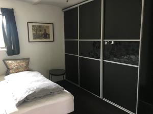 1 dormitorio con 1 cama y una gran pared de cristal en Tiklo Bed and Breakfast, en Arnborg