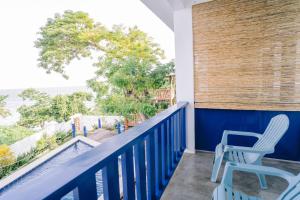 a balcony with two chairs and a view of the ocean at BlueWoods Seaside Resort in Dauis