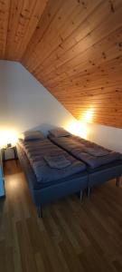 a bed in a room with a wooden ceiling at Villa Haaveranta - Private Villa by the lake in Rovaniemi