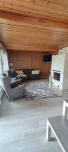 a living room with a couch and a table at Villa Haaveranta - Cosy cabin by the lake in Rovaniemi