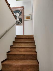 a staircase in a house with white walls and wooden floors at Camere D'artista in Enna