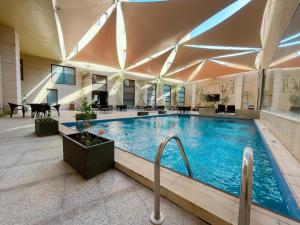 a large swimming pool in a large building at Voyage Hotel & Suites in Riyadh