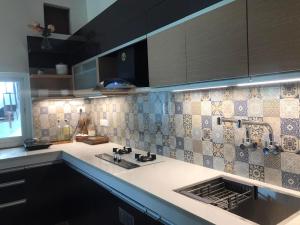 a kitchen with a sink and tiles on the wall at Mariya Condo hotel in Bodh Gaya