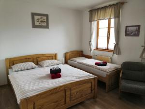 a bedroom with two beds and a chair at Hotel Gabriela in Vítkovice