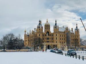 ein großes Gebäude mit Schnee davor in der Unterkunft Zum weißen Haus in Schwerin