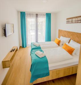 a bedroom with a large bed with blue curtains at Villa Nera - Etwa in Mostar