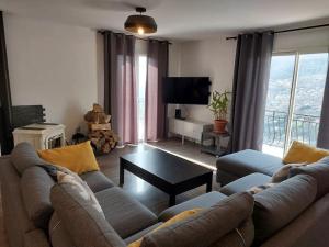 a living room with a couch and a table at Charmant haut de villa in Châteauneuf