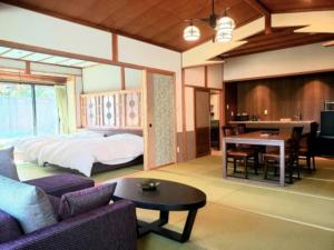 sypialnia z łóżkiem i salon ze stołem w obiekcie Saginoyusou w mieście Yasugi