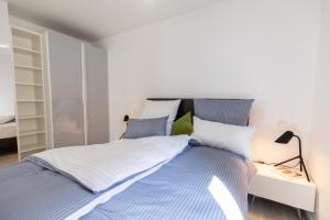 een slaapkamer met een bed met blauwe en witte lakens bij Appartement Champagne in Neuenstadt am Kocher