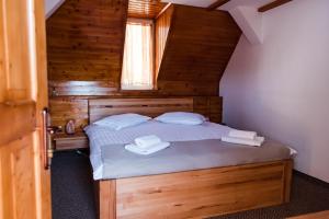 a bedroom with a bed with two towels on it at Gasthaus Hundorf in Viişoara