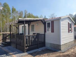 ein kleines Haus mit einer Veranda und einer Terrasse in der Unterkunft Holiday Park Auf dem Simpel in Soltau