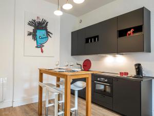 Coeur de ville, magnifique appartement + parking في بو: مطبخ مع طاولة خشبية وكاونتر