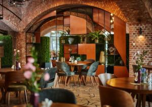 un restaurant avec des tables et des chaises et un mur en briques dans l'établissement Hotel Sphinx, à Żabia Wola