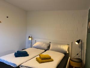 Dos camas en una habitación con toallas amarillas. en Ferienwohnung Marschkieker - Kleiner Deichhof, en Hattstedtermarsch