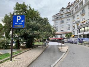 Coeur de ville, magnifique appartement + parking في بو: وجود علامة زرقاء لمواقف السيارات في شارع مجاور لمبنى