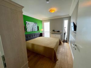 een slaapkamer met een bed en een groene muur bij Villa Hansa Binz App 4 am Kurpark Meine Ferienzeit in Binz