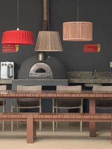 a restaurant with two tables and two pendant lights at Imbassaí Bahia Temporada Térreo in Imbassai