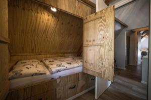 a wooden bed in a room with a wooden wall at Vakantiehuis in een prachtige bosrijke omgeving in Twente! in Bornerbroek +5 photos