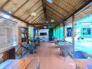 a restaurant with tables and chairs and a pool at Moon's house LuangPrabang in Luang Prabang