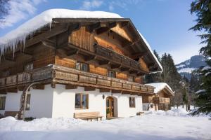 eine Blockhütte mit Schnee auf dem Dach in der Unterkunft Bauernhof Hintenberg in Itter