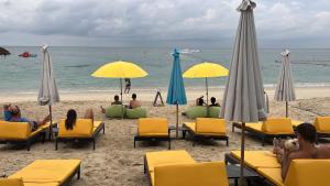 um grupo de pessoas sentadas na praia sob guarda-sóis em Pi3 Beach Resort em Lamai
