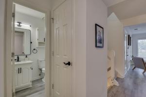 a white bathroom with a toilet and a sink at Beautiful 3BR Townhouse Close to Downtown Augusta in Augusta