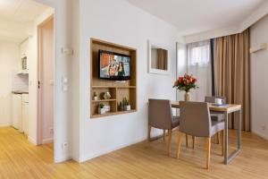 a dining room with a table and chairs at Citadines Croisette Cannes in Cannes