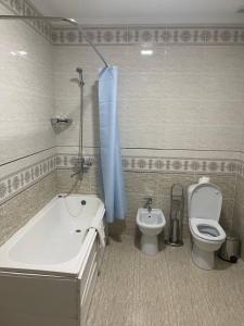 ブハラにあるGrand Shirin Palace Buxのバスルーム(バスタブ、トイレ、シンク付)