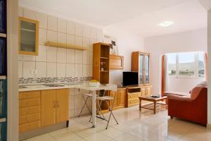 eine Küche mit Holzschränken und einem Tisch in der Unterkunft Casa Ferro in Las Palmas de Gran Canaria