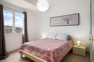een witte slaapkamer met een bed en een raam bij Casa Ferro in Las Palmas de Gran Canaria