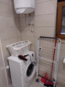 - un lave-linge et un sèche-linge dans une petite salle de bains dans l'établissement Apartmani Bernarda, à Poreč