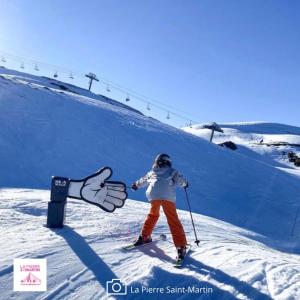 a person skiing down a snow covered slope with a giant hand at FLOR de MONTANHAS - 4PERS - Appart vacances in Arette