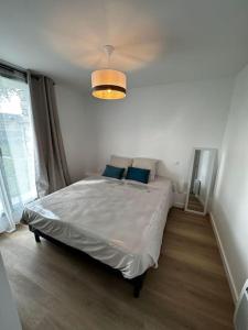 1 dormitorio con 1 cama grande con almohadas azules en Arz - 2 pièces neuf proche gare de Vannes, en Vannes