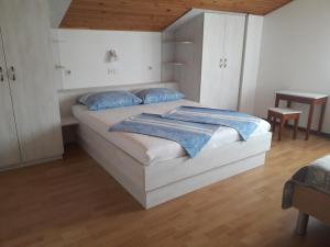 een slaapkamer met een groot wit bed met blauwe kussens bij Apartments Padovan 209 in Rab