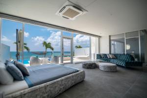 Schlafzimmer mit einem großen Bett und Meerblick in der Unterkunft Ronsard Resort IRABU in Miyako-jima