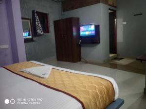 Habitación con cama y TV. en Skyry Hotel Iyyapanthangal en Chennai