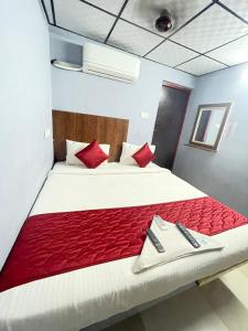 1 dormitorio con 1 cama grande con almohadas rojas en Skyry Hotel Iyyapanthangal en Chennai