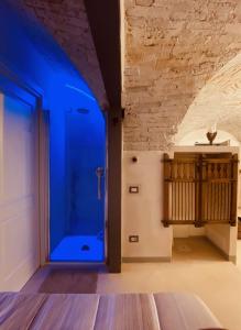 Habitación con baño con ducha con luz azul. en Vermaaten Boutique Suites Ruby, en Todi