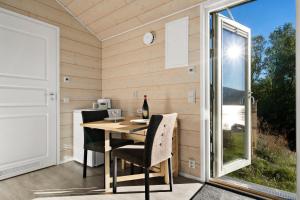 Habitación con mesa, sillas y ventana en Northern Light cottage 1, 