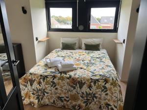 uma cama num pequeno quarto com duas toalhas em Het Wylde Pad - Let’s go Wylde! em Twijzelerheide
