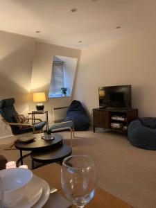 a living room with couches and a flat screen tv at The Riding Gate Apartment in Kent