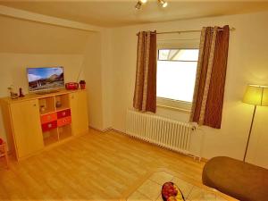 een woonkamer met een bank, een televisie en een raam bij Ferienwohnungen Segebrecht Ahlbeck in Ahlbeck