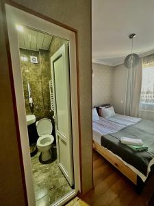 a small bathroom with a bed and a toilet at Guest house chavchavadze N23 in Kazbegi