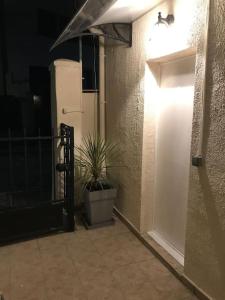 un couloir avec une porte blanche et une plante en pot dans l'établissement La petite maison, à Bobigny