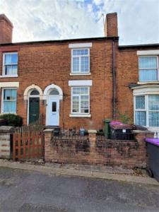 a brick house with a fence in front of it at Nice 4-bedroom vacation home with indoor fireplace in Wellington